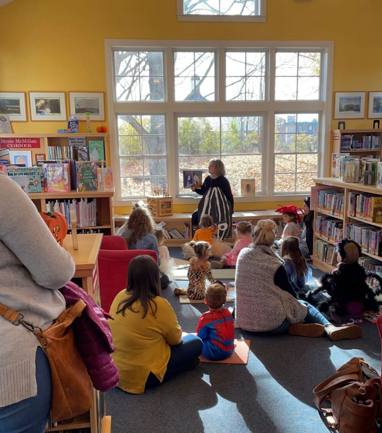 Children and parents gathered on the rug for story time in the library’s Children’s Room